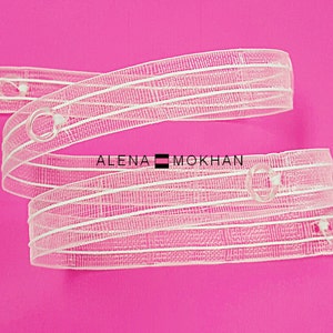 May include: White sheer curtain tape with white lines and clear plastic rings. The tape is rolled up and the text "ALENA MOKHAN" is visible.