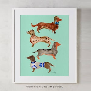 Puede incluir: Una pintura de acuarela de cuatro dachshunds sobre un fondo verde claro. Los dachshunds son de diferentes colores y tienen diferentes expresiones. La pintura est&aacute; enmarcada en un marco blanco.