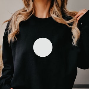 May include: Black sweatshirt with a large white circle on the front.