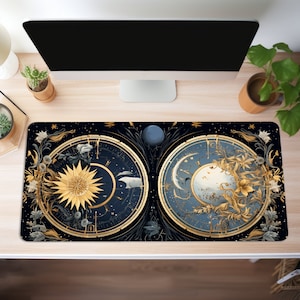May include: A black and gold mouse mat with a celestial design featuring two circular clocks, one with a sun and the other with a moon. The clocks are surrounded by floral details and stars.
