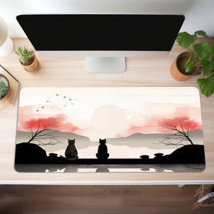 Può includere: Un dipinto ad acquerello di un tramonto su una catena montuosa con due gatti neri seduti su uno scoglio vicino a un lago. Il cielo è di un rosa e un arancio delicati, e il sole tramonta dietro le montagne. I gatti sono in silhouette contro il tramonto.