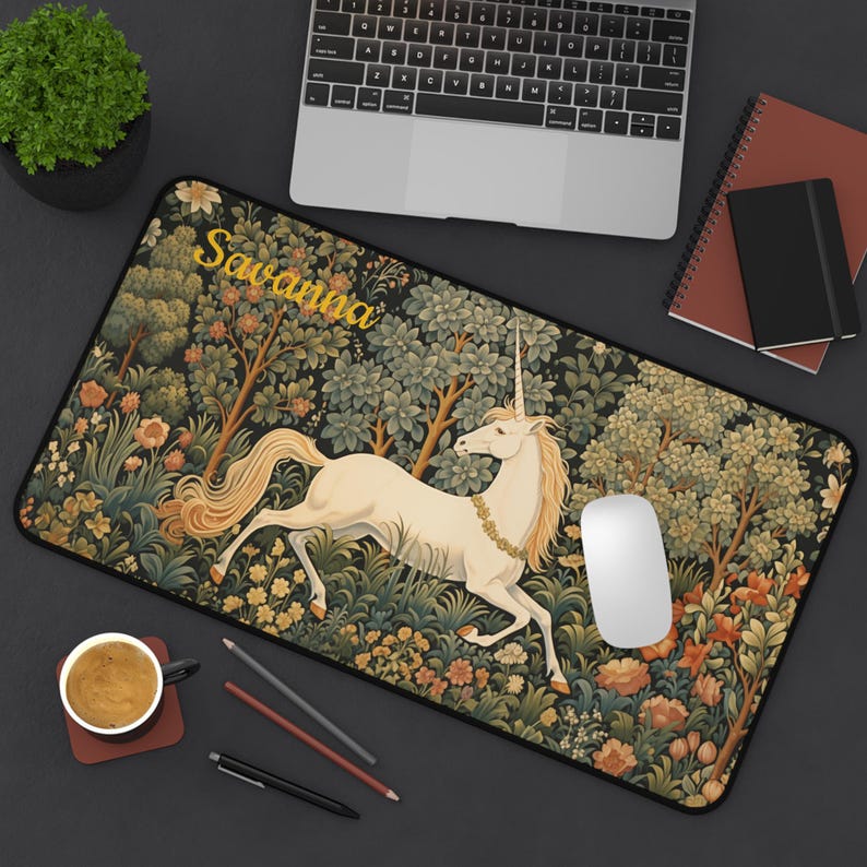 Pu&ograve; includere: Un tappetino per mouse nero con un design a tappezzeria colorato che presenta un unicorno bianco che corre attraverso una foresta. Il nome "Savanna" &egrave; scritto in lettere gialle nella parte superiore del tappetino per mouse.