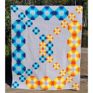 Könnte beinhalten: Eine Steppdecke mit einem geometrischen Muster aus blauen, gelben und orangen Ananas. Die Steppdecke hat einen weißen Hintergrund und ein modernes Design.