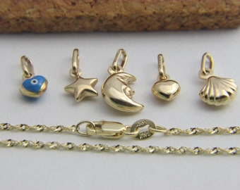 May include: A gold chain necklace with a variety of charms, including a heart with a blue evil eye, a star, a crescent moon, a heart, and a seashell.