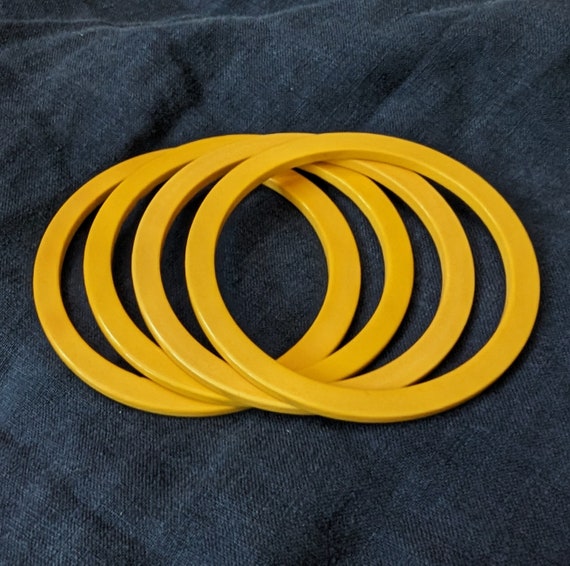 Four thin square edged yellow Bakelite bracelets.… - image 1