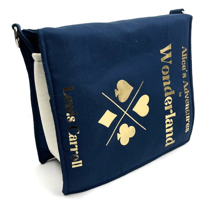 May include: A navy blue canvas tote bag with a gold design featuring playing card suits and the text "Alice's Adventures in Wonderland" and "Lewis Carroll".