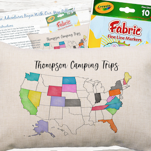 May include: A white pillow with a map of the United States on it. The map is divided into states, each of which is colored in a different color. The pillow is labeled "Thompson Camping Trips".