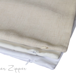 May include: Close-up of three pillow covers in neutral tones. The top pillow cover is a light beige linen, the middle one is a white linen, and the bottom one is white cotton. The words "Hidden Zipper" are written in cursive.