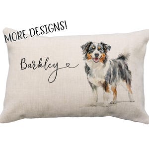 May include: A beige linen pillow with the name "Barkley" and a heart symbol. A watercolor painting of an Australian Shepherd dog is on the pillow.