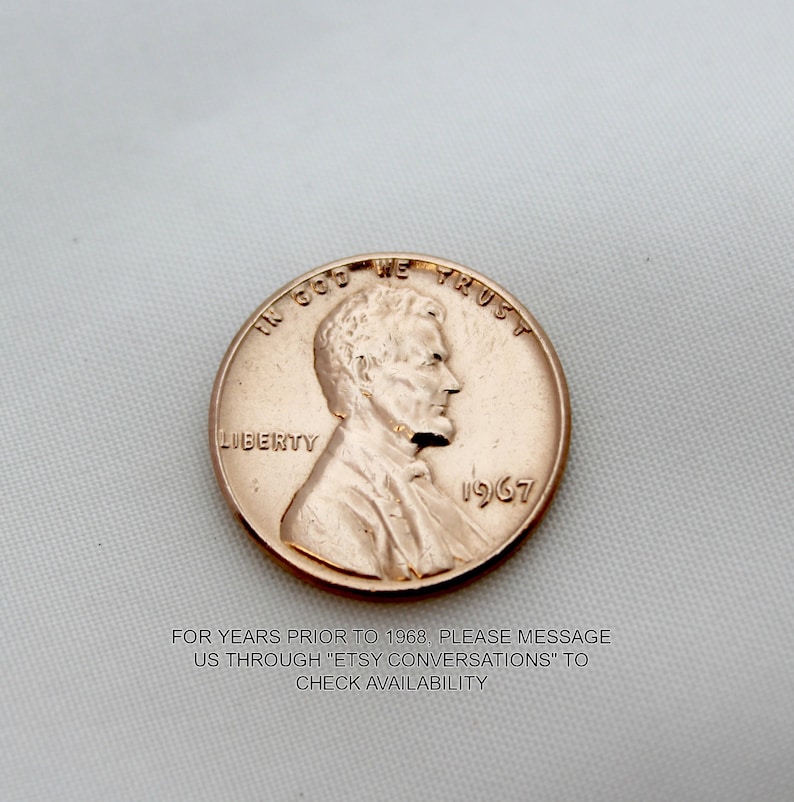 May include: A copper-colored 1967 US penny coin with the words "In God We Trust" and "Liberty" inscribed on it. The coin features a profile of Abraham Lincoln.