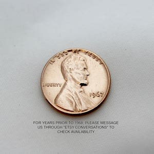 Pu&ograve; includere: Una moneta da un centesimo americana in rame del 1967 con le parole "In God We Trust" e "Liberty" incise su di essa. La moneta presenta un profilo di Abraham Lincoln.