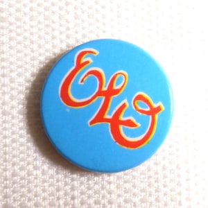 May include: A blue button with the ELO logo in red and yellow lettering.