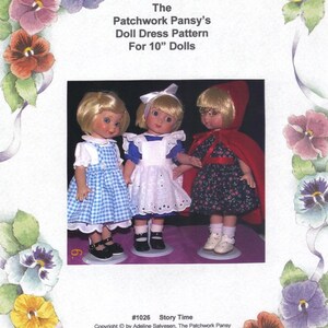 May include: Three 10-inch dolls wearing different dresses. The doll on the left is wearing a blue and white gingham dress with a white collar and a white apron. The doll in the middle is wearing a white dress with a white lace trim and a white apron. The doll on the right is wearing a red hooded dress with a black and white floral print.