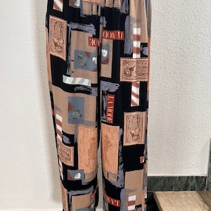 Könnte beinhalten: Schwarze weite Hose mit einem braunen, weißen und roten geometrischen Muster mit dem Text "La Mode".