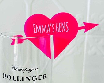 Peut inclure: Charme de verre à champagne en forme de cœur rose avec une flèche et le texte "Emma's Hens".