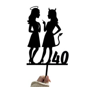 Puede incluir: Topper de pastel de silueta negra con dos figuras, una con alas de ángel y un halo, la otra con cuernos de diablo y una cola. Las figuras se miran y el número 40 está debajo.