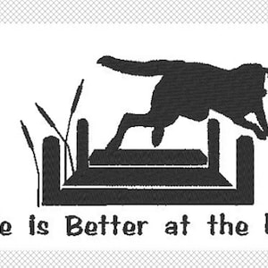 May include: Black silhouette of a dog jumping over a dock, with cattails and the text "Life is Better at the Lake." The design is on a white background, suitable for lake-themed decor or apparel.
