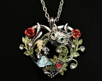 Hand-painted Alice in Wonderland-inspired heart-shaped pendant necklace with Alice, the Cheshire Cat, and Ace of Hearts playing card charms