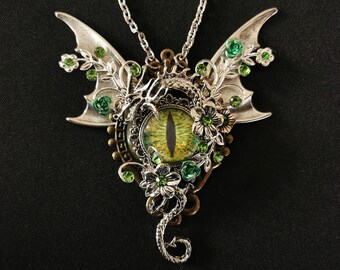 May include: A silver dragon pendant necklace with a green eye, silver wings, and green floral accents.