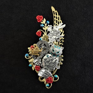 Alice In Wonderland-inspired pin brooch - Filigree winged corsage-style brooch with Alice-themed charms