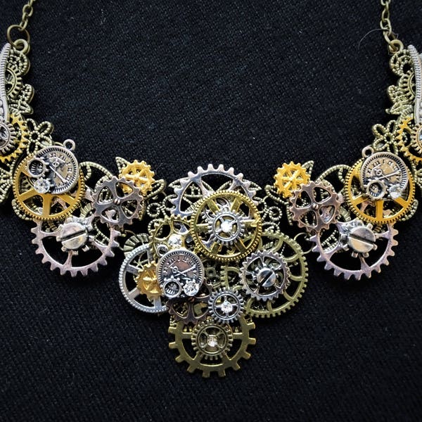 Magnifique collier steampunk avec engrenages, rouages, petites montres de poche et ailes en bronze, or, cuivre et argent + cristaux en strass