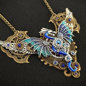 May include: A steampunk-style necklace featuring a blue and green dragon with intricate metal gears and blue crystals.