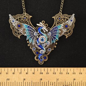 May include: A silver and blue steampunk dragon necklace with intricate details and blue and clear rhinestones.
