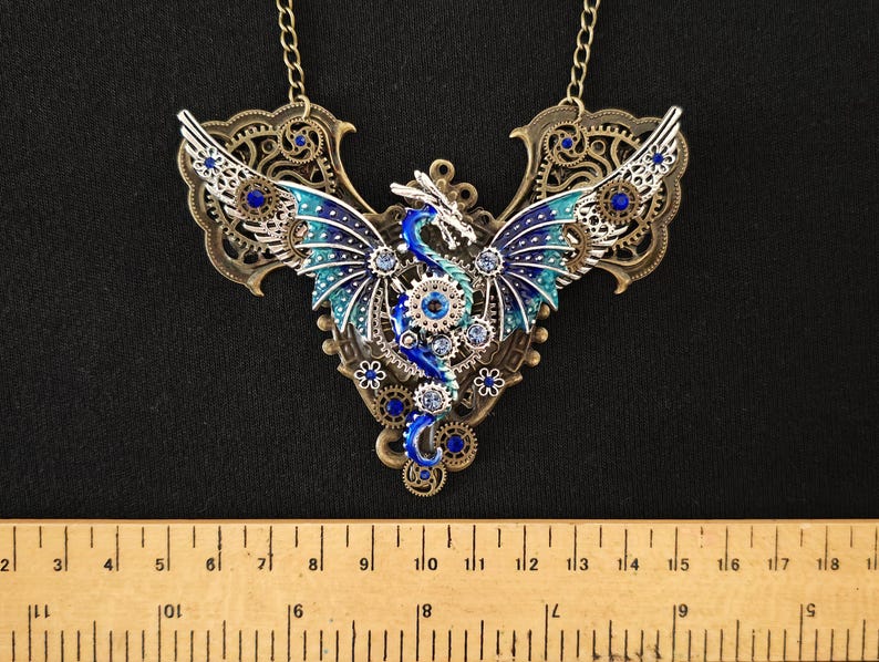 May include: A silver and blue steampunk dragon necklace with intricate details and blue and clear rhinestones.