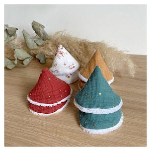 Puede incluir: Cuatro baberos para bebé en forma de cono en rojo, blanco floral, amarillo mostaza y verde azulado. Cada babero tiene un ribete blanco esponjoso y adornos dorados. Los baberos están apilados sobre una superficie de madera.