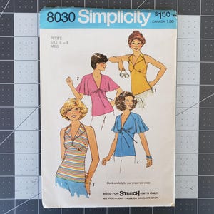 Puede incluir: Un patrón de costura para una blusa con un nudo en el cuello. El patrón es solo para tejidos de punto elásticos e incluye las tallas 6-8. El patrón es de Simplicity y es el número 8030.