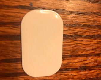 May include: A white oval sticker with a glossy finish.