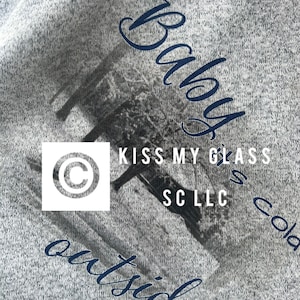 May include: Gray sweatshirt with a blue graphic of a butterfly with the text "Baby" and "Kiss My Glass" and a copyright symbol. The text "SC LLC" is also included in the graphic.