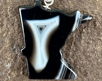 Puede incluir: Colgante de ágata negro y blanco con forma del estado de Minnesota. El colgante está unido a una cadena de plata.