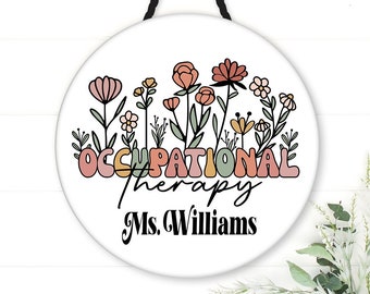 May include: White round sign with a floral design and the text "Occupational Therapy Ms. Williams".