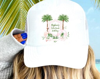 May include: White trucker hat with a mesh back and a front panel featuring a tropical design with palm trees and the text "Meghan's Palm Beach Birthday". The hat is worn by a person with blonde hair, against a backdrop of palm leaves and ocean.