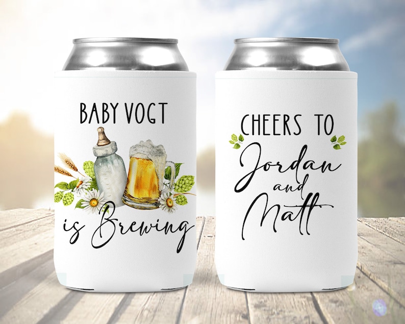 Puede incluir: Dos enfriadores de latas blancos con tem&aacute;tica de baby shower. Un enfriador dice "Baby Vogt is Brewing" con una ilustraci&oacute;n de biber&oacute;n y jarra de cerveza. El otro enfriador dice "Cheers to Jordan and Matt".