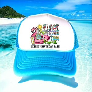 May include: A white and blue trucker hat with a pink flamingo float, a cocktail, and the text "Float Drink Tan Repeat Leslie's Birthday Bash".