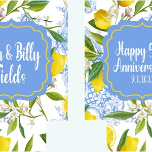 Puede incluir: Dos etiquetas enmarcadas en azul y dorado con dise&ntilde;os de limoneros. La etiqueta de la izquierda dice "Jan & Billy Fields". La etiqueta de la derecha dice "Feliz 50 aniversario! 9.1.2023".