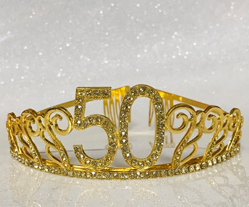 May include: Gold-colored tiara with rhinestones, featuring the number "50" in the center.