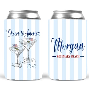 May include: Two beverage can coolers featuring a light blue and white vertical striped pattern. One cooler displays two martini glasses with olives, American flag picks, the text Cheers to America, and 2026. The other displays the name Morgan and Rosemary Beach.