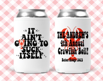 May include: Two white can coolers with red crawfish designs. The left cooler says "It ain't going to suck itself." The right cooler says "The Andrew's 4th Annual Crawfish Boil! Baton Rouge 2023."
