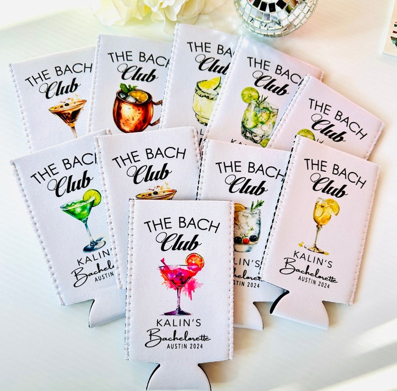 Pu&ograve; includere: Un set di nove refrigeratori per lattine bianchi con il testo "The Bach Club" e varie illustrazioni di cocktail. I refrigeratori hanno il testo "Kalin's Bachelorette Austin 2024" stampato su di essi.