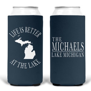May include: Two blue and white can coolers. One cooler says "Life is better at the lake" with an outline of the state of Michigan. The other cooler says "The Michaels Lake Michigan".
