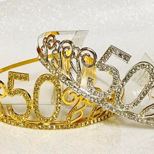 May include: Two gold and silver tiaras with rhinestones and the number 50 on them. The tiaras are decorated with swirls and are perfect for a 50th birthday party.