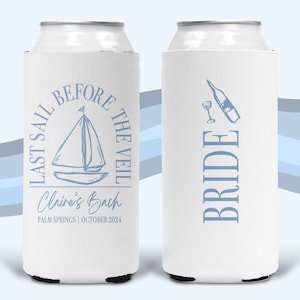 May include: Two white foam can coolers featuring light blue graphics. One side displays a sailboat with the text "LAST SAIL BEFORE THE VEIL," "Claire's Bach," and "PALM SPRINGS | OCTOBER 2024." The other side shows a wine bottle, glass, and "BRIDE."