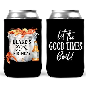 Puede incluir: Dos neveras negras para latas con texto blanco. Una nevera presenta un dibujo de una olla de cangrejos de río con una botella de cerveza y el texto "Blake's 30th Birthday". La otra nevera tiene el texto "Let the Good Times Boil!"
