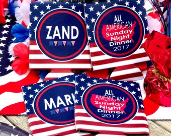 May include: Four red, white, and blue can coolers with an American flag design. Two coolers have the text "ALL AMERICAN Sunday Night Dinner 2017" and a map of the United States. The other two coolers have a circle with the text "ZAND" and "MARK" inside.