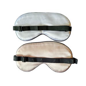 May include: Two sleep masks, one light blue and one light beige, with adjustable black elastic straps.