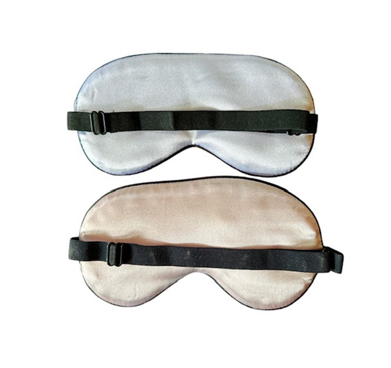 May include: Two sleep masks, one light blue and one light beige, with adjustable black elastic straps.