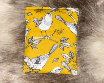 May include: A mustard yellow fabric pouch with a black and white bird print. The pouch has a zipper closure and is perfect for storing small items.